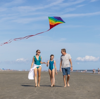 family flying a kite on the beach