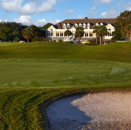 large white building set behind a pristine golf green