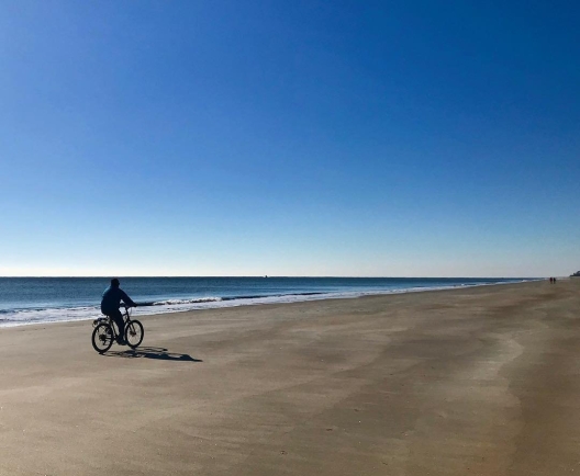 man on bike on beach