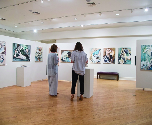 Two people standing in an art gallery