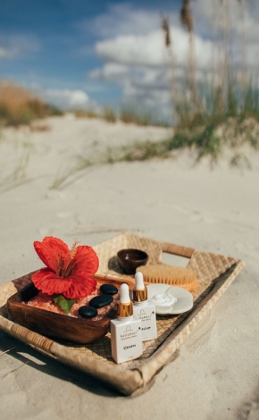 spa products on a stay on the beach with a red flower