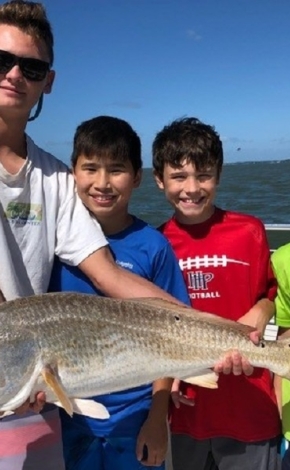 a man with three kids holding a fish they caught