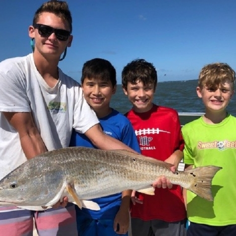 a man with three kids holding a fish they caught