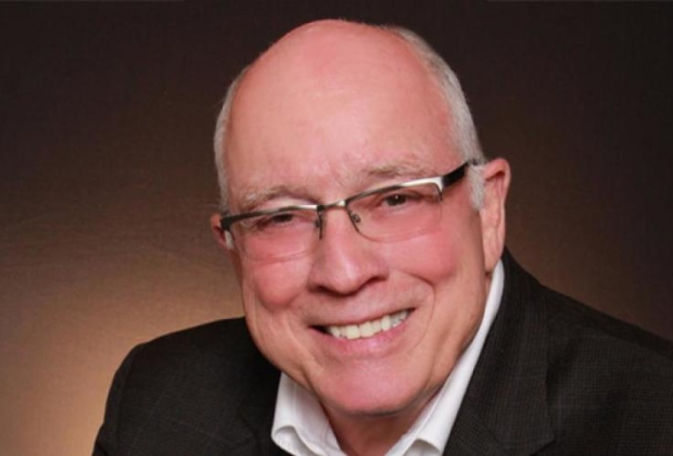 Man with glasses smiles for the camera