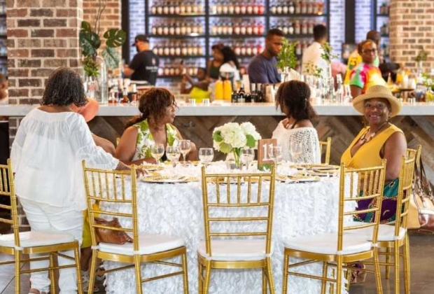 Four ladies sat at a table posing for camera