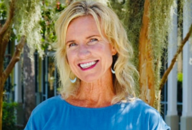 A woman in blue poses for camera