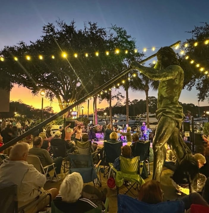 Band plays outside at night circled by their audience