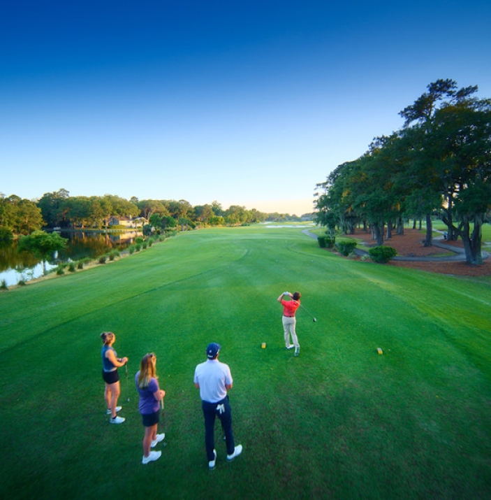 Group of golfers teeing off