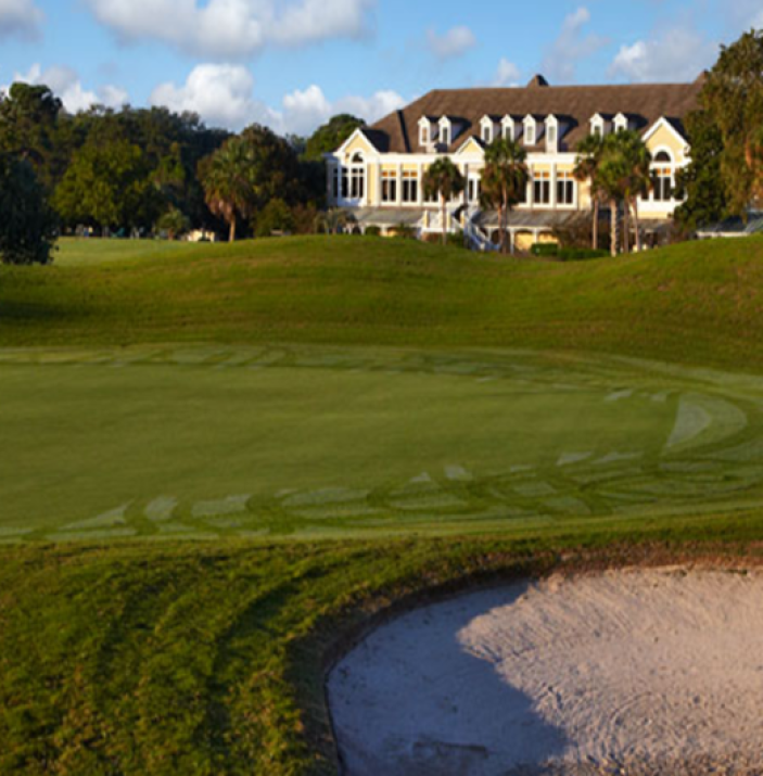 Golf course green with clubhouse in the distance