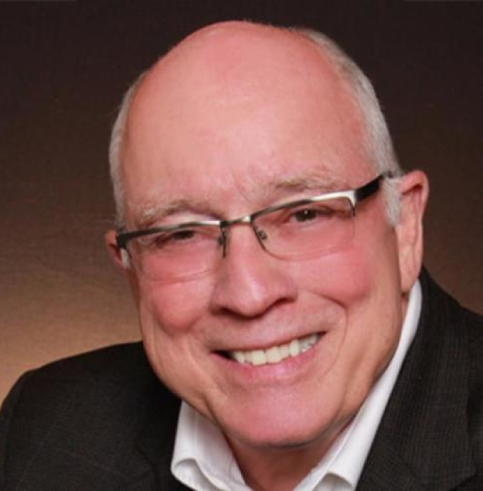 Man with glasses smiles for the camera